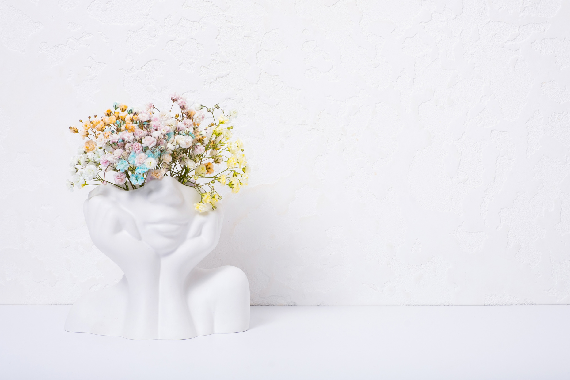 Creative plaster vase head-shape with colorful flowers. Mind car